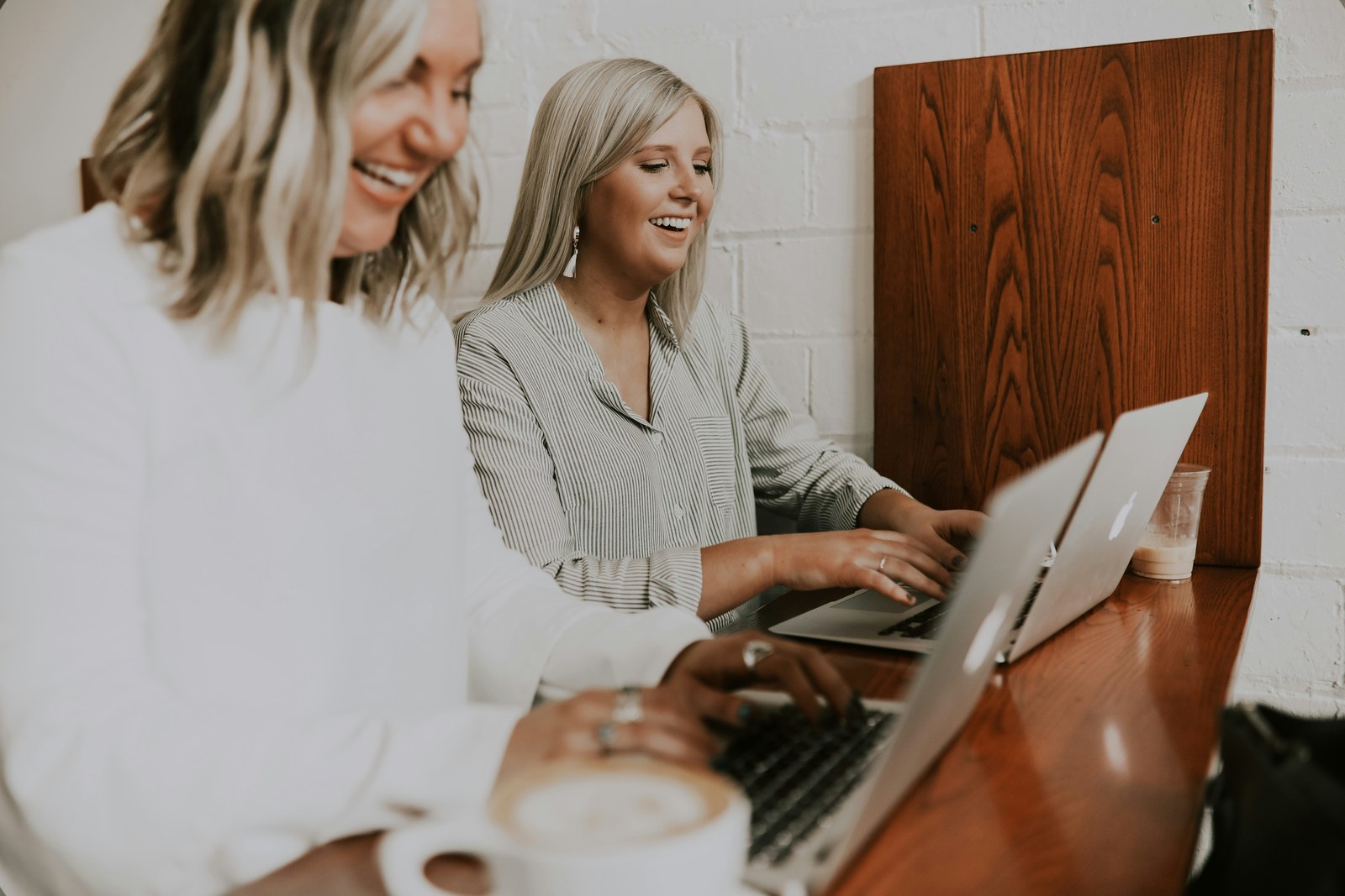 Zwei Frauen lachen und arbeiten gemeinsam am Laptop — Community bei Finelle